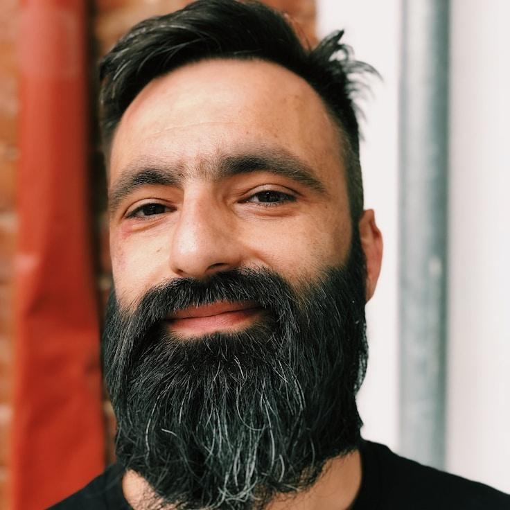 Alex Rivera, Lead Design Curator at SurgeSpringRipple, reviewing corporate floral arrangements